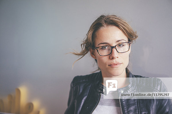 Portrait einer jungen Frau mit Brille und Lederjacke