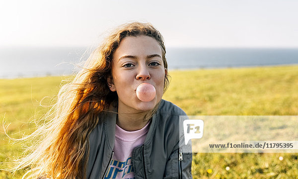 Teenager-Mädchen macht eine Kaugummiblase im Freien