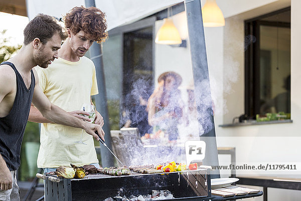Two men at barbecue grill