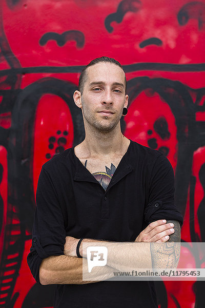 Porträt eines Mannes vor einer Graffiti-Wand