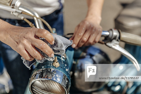 Close-up of woman cleaning vintage motorcycle