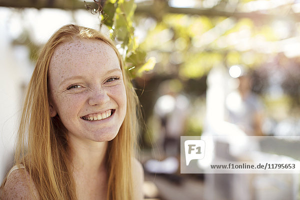 Porträt eines glücklichen Mädchens mit langen roten Haaren