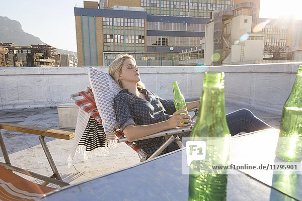 Junge Frau entspannt sich auf ihrer Terrasse