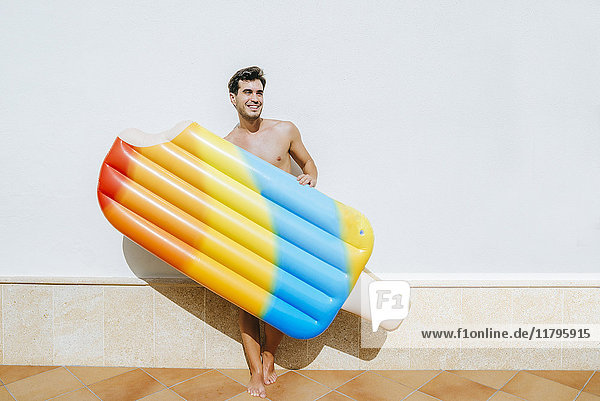 Man with ice cream float in front of white wall