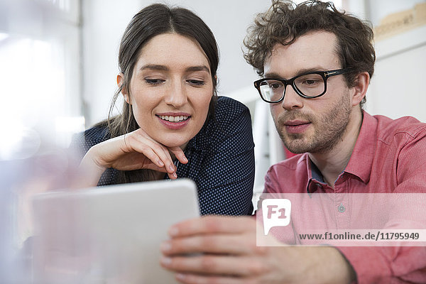 Man and woman looking at tablet in office
