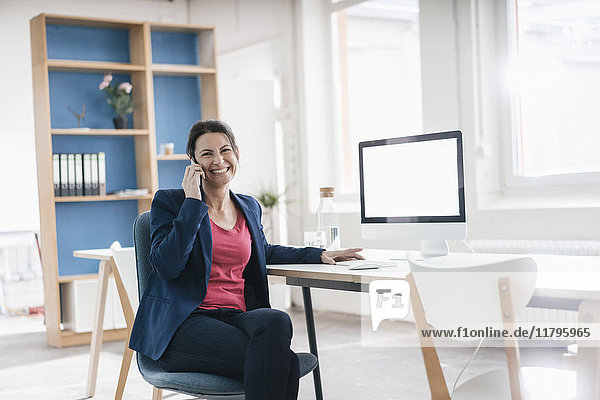 Portrait of businesswoman sitting at desk in a loft