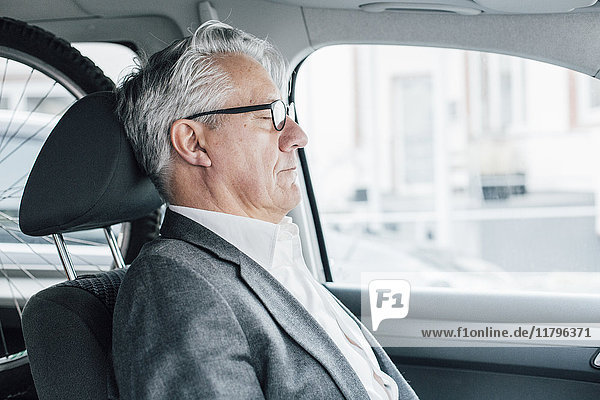 Senior Geschäftsmann sitzend im Auto mit geschlossenen Augen