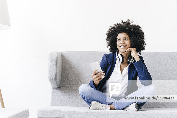 Junge Geschäftsfrau mit Smartphone und Headset