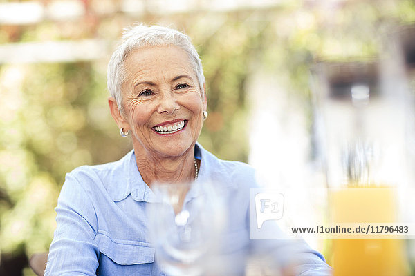 Porträt einer lächelnden Seniorin im Freien