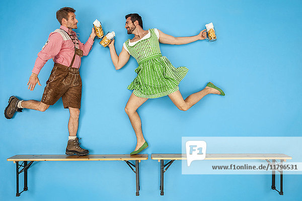 Gay couple at the Oktoberfest dancing on beer benches