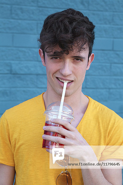 Porträt eines jungen Mannes  der Erfrischungsgetränk trinkt