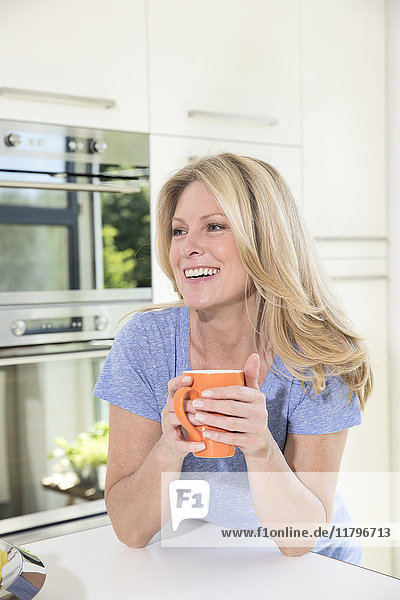Happy woman at home with cup of coffee