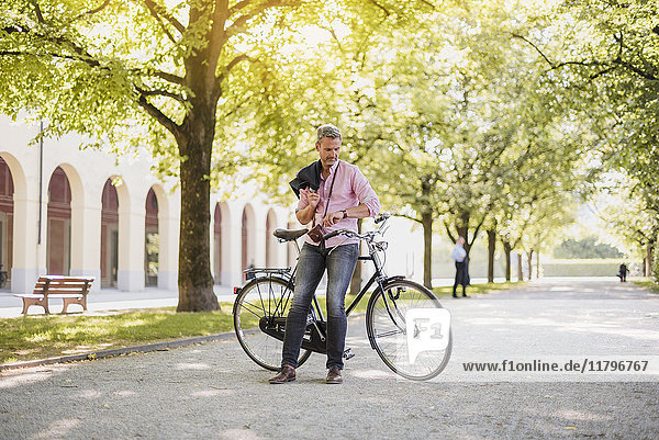 Mann mit Fahrrad im Park bei einer Pause