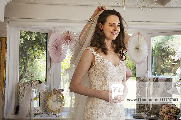Eine zukünftige Braut  eine junge Frau  die Brautkleider in einer spezialisierten Brautboutique anprobiert.