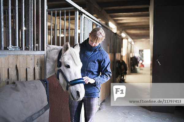 Woman with horse in stable