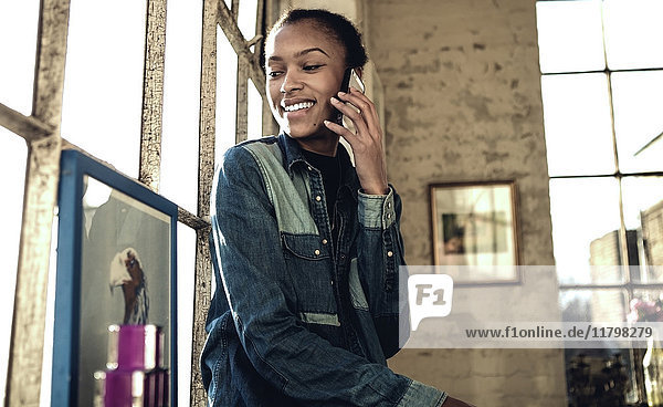Eine junge Frau in einer Dachgeschosswohnung beim Telefonieren.