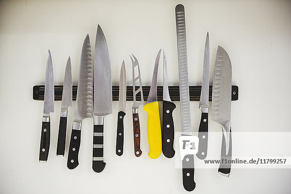Nahaufnahme einer Auswahl von Messern auf einem Magnetstreifen in einer Küche.