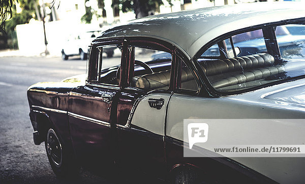 Nahaufnahme eines klassischen Autos aus den 1950er Jahren  das an einer Straße geparkt ist.