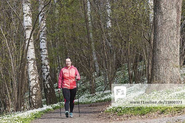 Frau Nordic Walking im Frühlingswald