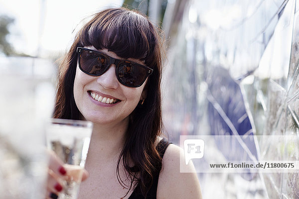 Lächelnde Frau mit Getränk in der Hand