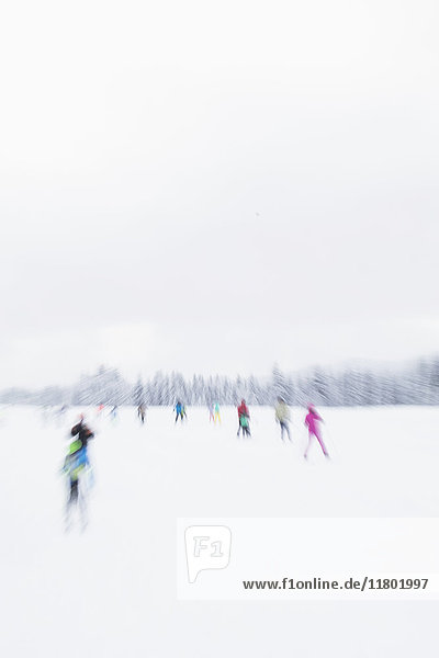 Unscharfes Bild von Menschen beim Skifahren im Schnee