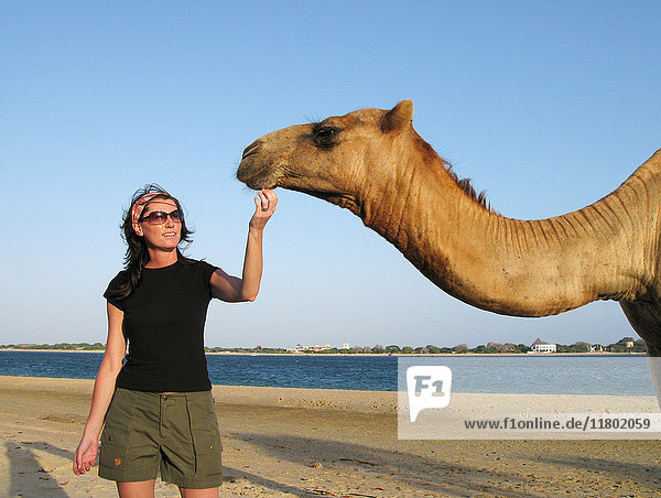 Frau stehend mit Kamel