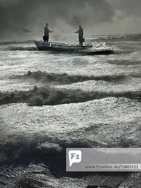 Two businessmen reaching to shake hands in boat on stormy sea