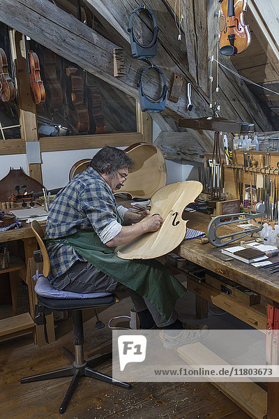 Handwerker bei der Arbeit an einer Geige in der Werkstatt