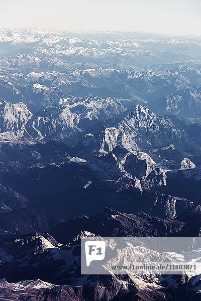 Aerial view of rocky mountain range covered with snow
