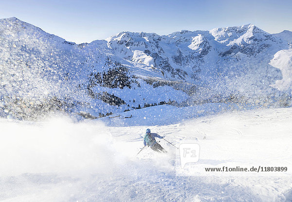 Mann beim Skifahren auf Schnee gegen den Himmel