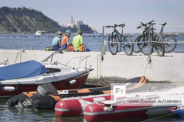 Radfahrer  die sich mit ihren Fahrrädern auf einem aufblasbaren Floß auf dem Steg ausruhen