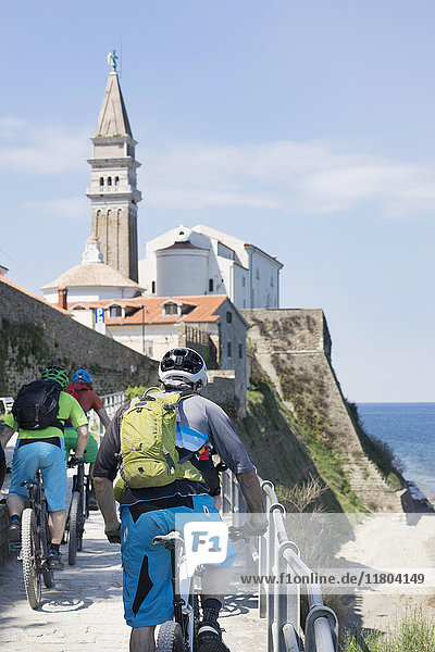 Radfahrer radeln zur Kirche am Meer