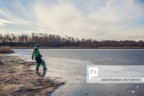 Boy playing at frozen lake
