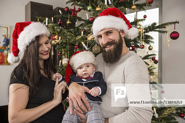 Portrait of family against Christmas tree