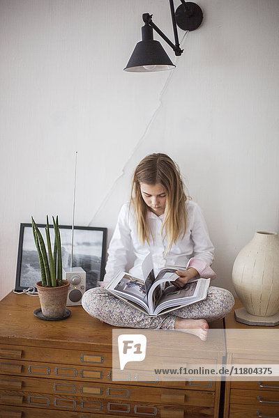 Girl reading book in living room
