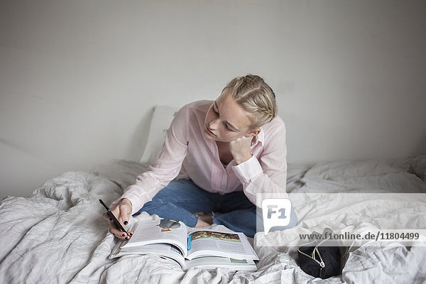 Teenager-Mädchen liest auf dem Bett