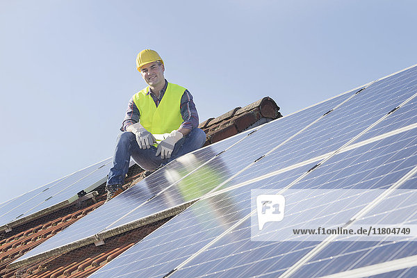 Ingenieur macht Pause bei der Installation von Solarzellen auf dem Hausdach