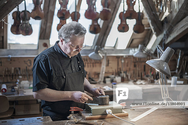 Craftsman working at violin workshop