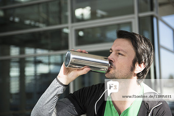 Man in sportswear drinking water after workout