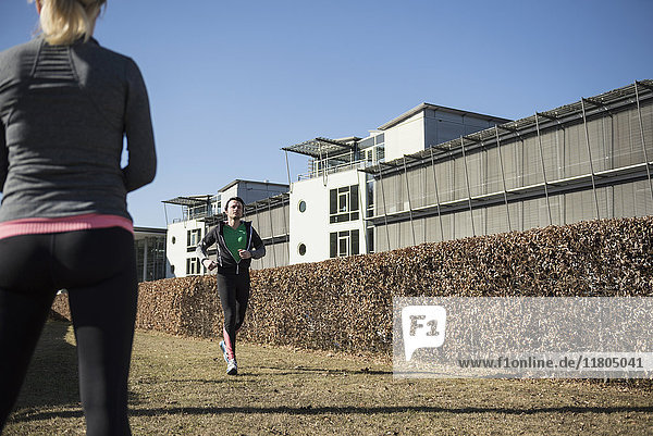Woman observing man jogging outdoors