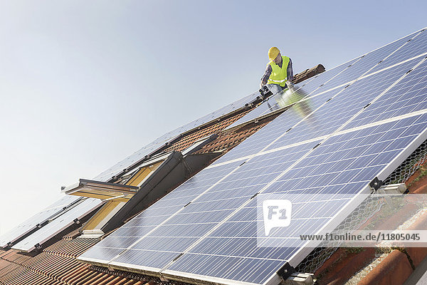 Ingenieur auf dem Dach bei der Installation von Sonnenkollektoren