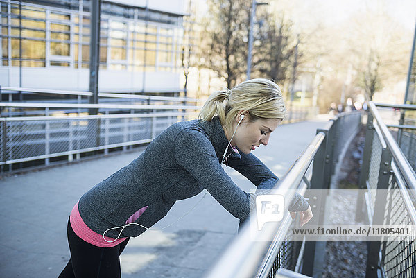 Exhausted woman resting on bridge after workout