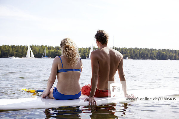 Couple sitting on paddleboard