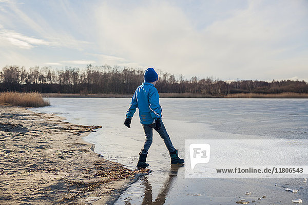 Boy playing at frozen lake