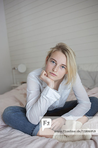 Porträt eines im Schlafzimmer sitzenden Teenagers