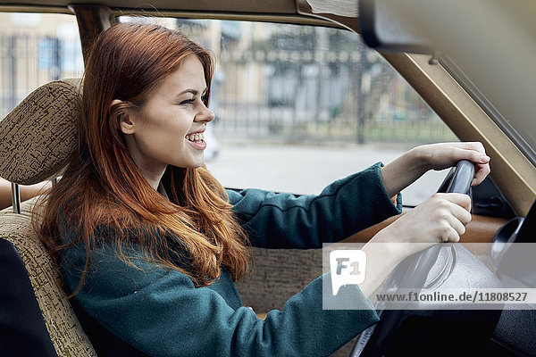 Lächelnde kaukasische Frau am Steuer eines Autos