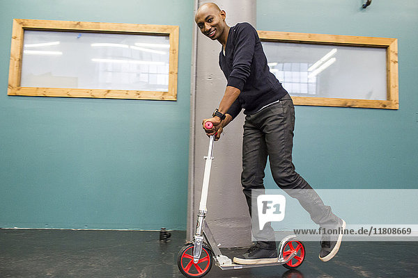 African American man riding scooter indoors