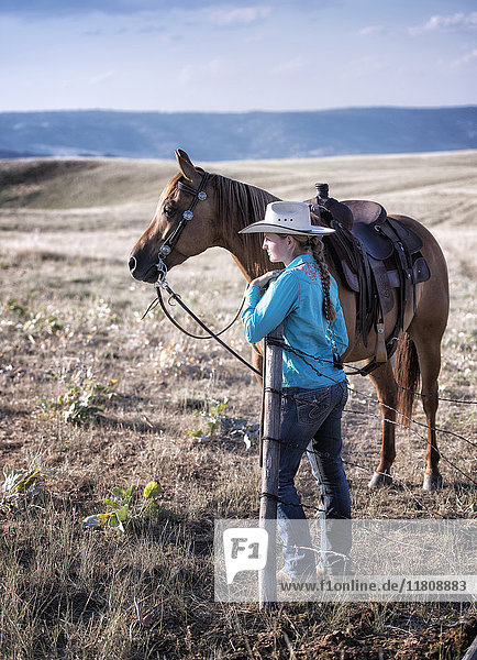 Kaukasisches Mädchen auf einem Feld mit Pferd