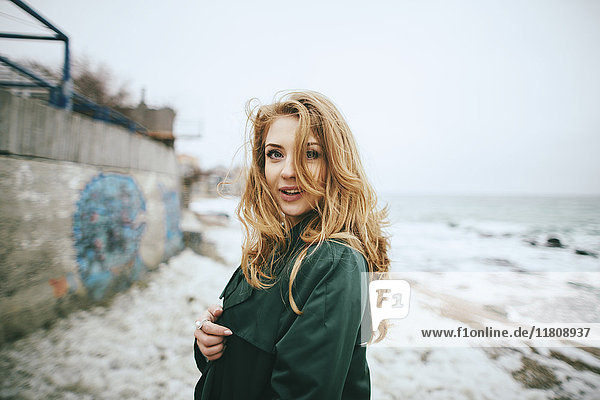 Porträt einer lächelnden kaukasischen Frau am Strand