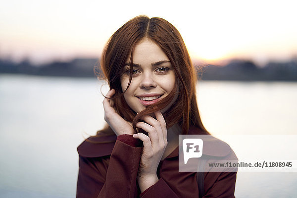 Portrait of smiling Caucasian woman at waterfront